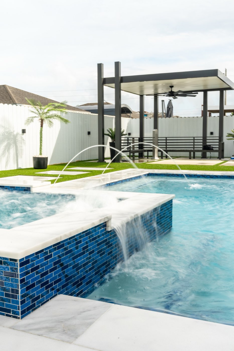 Custom pool with raised blue-tile spa and sheer descent waterfall, Miami FL